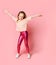 Cute blonde kid in t-shirt and leggings. She smiling and dancing , posing on pink studio background. Close up