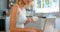 Cute blonde using laptop in kitchen