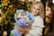 Cute bouquet of white peonies and blue hydrangea in hands of smiling blonde woman