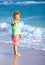 Cute boy on beach, showing victory gesture