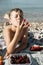 Cute boy with berries and sunglasses on a pebbles beach near sea