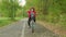 Cute boy bicyclist riding on bicycle in summer park. Portrait curly boy riding on bike at asphalt path in autumn park.