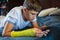 Cute boy with broken hand relaxing and smiling on the couch. Close up young handsome Teenage with yellow plaster