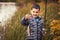 Cute boy catches fish on a summer lake