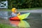 Cute boy with colorful rainbow umbrella on a rainy day, having f