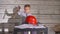 Cute boy constructor in working clothes and helmet. Boy engineer working on a project with a hammer in his hands. On the
