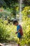 A cute boy dressed as superman showers in the garden