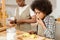 Cute boy eating raw apples while chopping ingredients