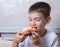 Cute boy eating a slice of pepperoni and cheese pizza, the child closed his eyes in pleasure, close-up, copy space