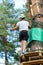 Cute boy enjoying activity in climbing adventure park at sunny summer day. Kid climbing in rope playground structure.
