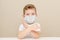 Cute boy of four years in a medical mask. Quarantined children due to an epidemic. The boy forbids. Gesture - hands are skrenny