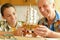 Cute boy with grandfather making wooden model