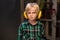 Cute boy with headphones and safety glasses in a carpenter`s workshop, portrait.