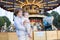 Cute boy and his baby sister standing in front of a carousel