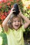 Cute boy hold avocado on head, close up portrait on at tropical garden.