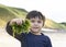 Cute boy holding seaweed with proud face on sunny day,Active boy showing fresh seaweed from the beach sand with bright light, Chil