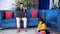 Cute boy with long hair playing with his toys while sitting on the floor at home - father and son, single father, busy parent