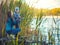 Cute boy with mom catches fish on a summer lake.