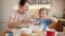 Cute boy with mother sifting flour with sieve for cake or pie dough. Children cooking with parents, little chef, family