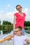 Cute boy paddling with mother in boat. Active happy boy having f