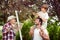 Cute boy picking cherries with his dad and grandfather