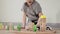Cute boy plays with a wooden train, takes him across the bridge on flights. Wooden educational toys