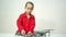 A cute boy in a red shirt is installing a drone`s propeller.