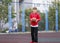 Cute boy in red t shirt plays basketball on city playground. Active teen enjoying outdoor game with orange ball. Hobby