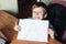 Cute boy shows page with handwritten letter A