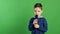 Cute boy singing song while holding microphone and showing thumb smiling at camera, karaoke fun entertainment for kids