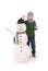 Cute boy with snowman with scarf and hat