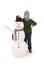 Cute boy with snowman with scarf and hat