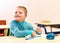 Cute boy with special needs writing letters while sitting at the desk in class room