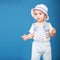 Cute boy standing against a blue background wearing a sailor