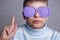 Cute boy in violet sunglasses with opaque lenses pointing upward