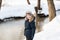 Cute boy walking along a frozen brook on a winter day