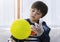 Cute boy wearing disposable protective plastic glove and holding yellow balloon,Kid preparing science project about static charged