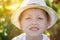 Cute boy wearing hat and smiles. Summer day. Caucasian little boy in a summer hat outdoors