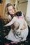 Cute bride hugging funny pug dog with pink bow tie in morning  before wedding ceremony in hotel room.Girl with her dog. Pets at