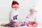 Cute brother siblings, kids in santa`s hats and garland playing at home