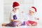 Cute brother siblings, kids in santa`s hats and garland playing at home