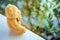 Cute brown teddy bear sitting on white table next glass window seeing  nature outside feeling lonely