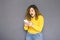 Cute brunette plus size woman with curly hair in yellow sweater