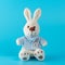 Cute bunny doll on blue background. Minimal Easter concept