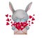 A cute bunny holds an envelope with red hearts in its paws. Romantic clipart.
