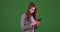 Cute Businesswoman intern using smartphone to communicate on green screen