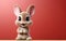 cute cartoon character hare rabbit bunny points paw at copy space on an orange isolated background