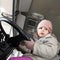 Cute Caucasian baby girl driving big cargo truck