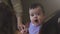 Cute caucasian baby girl wearing a bib sitting and yawning on a wooden high chair