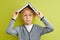 cute caucasian boy put book on his head, looking up wondering